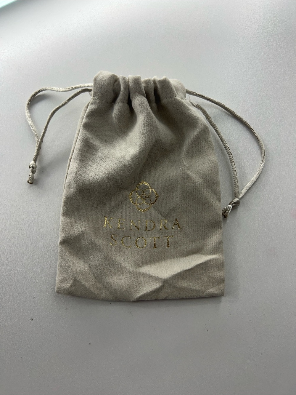 Kendra Scott Taupe Drawstring Jewelry Pouch with gold necklace